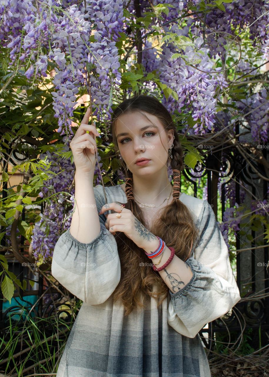 Portrait of Young Girl on Background of Purple Flowers