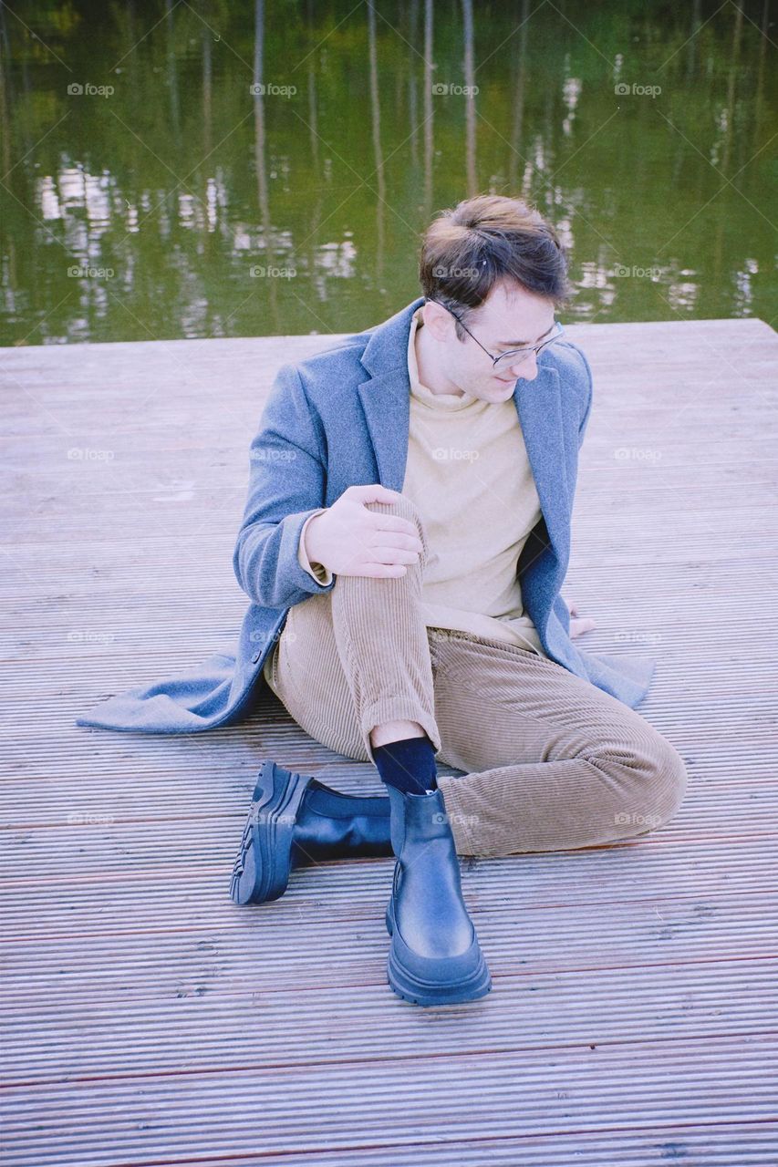 Portrait of a young smiling man in a coat