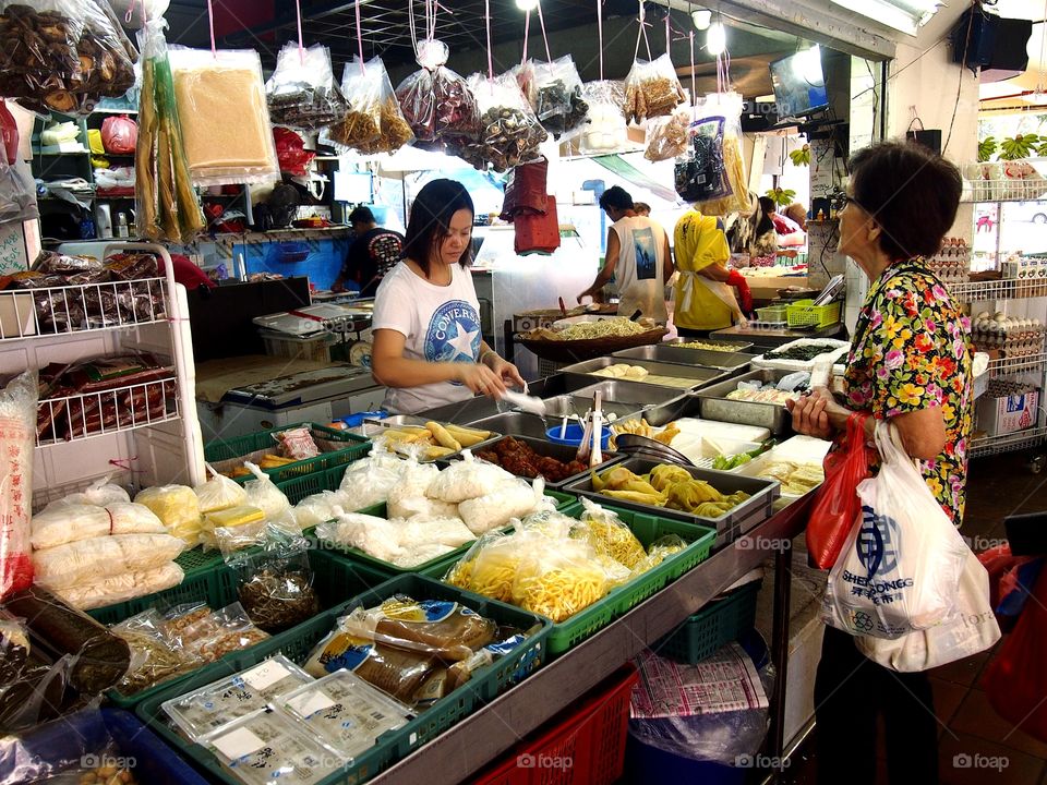 a lady buying fresh seafoods at a market