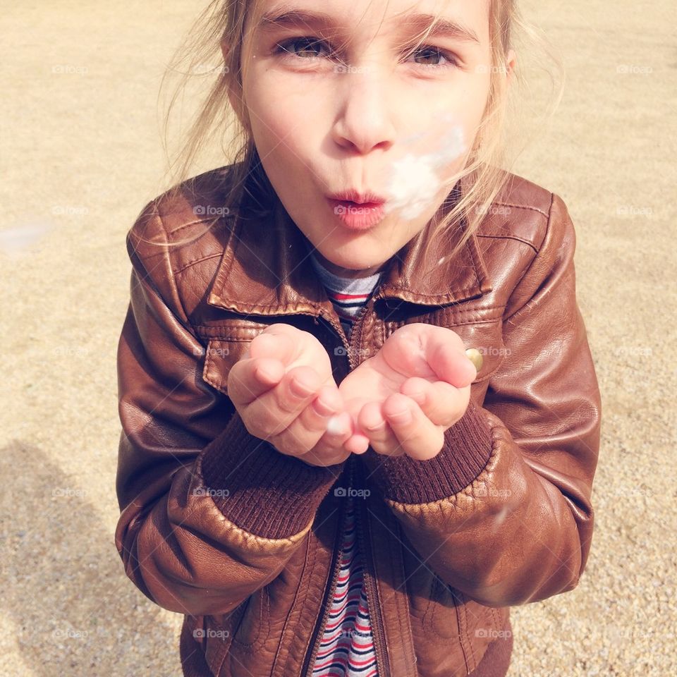 Girl blowing the seeds