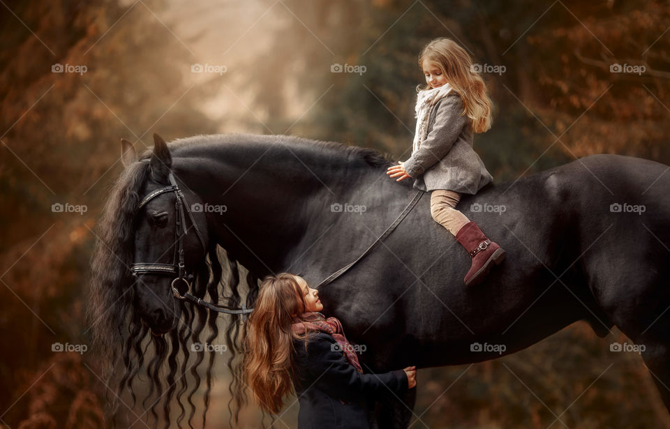 Portrait of little sisters with  horse