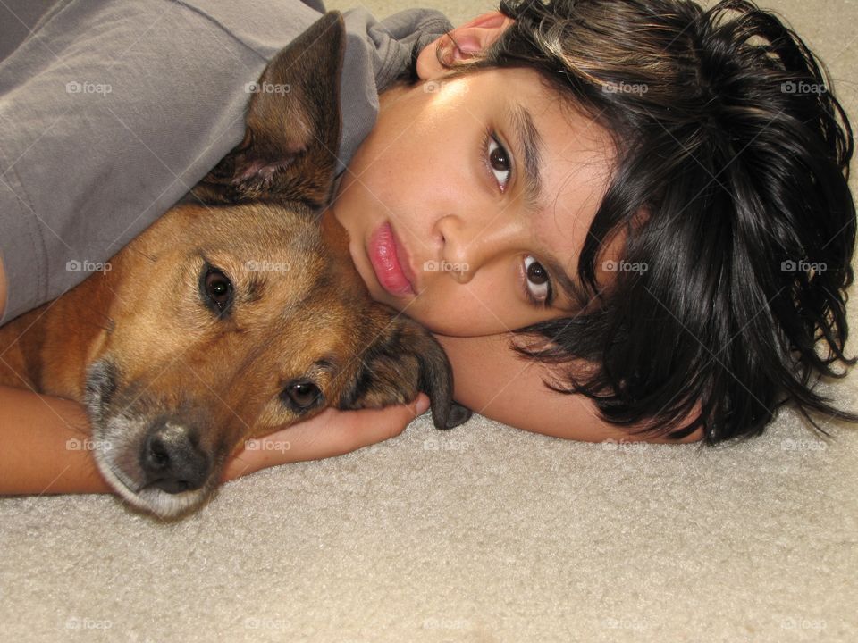Close-up of boy with dog at home