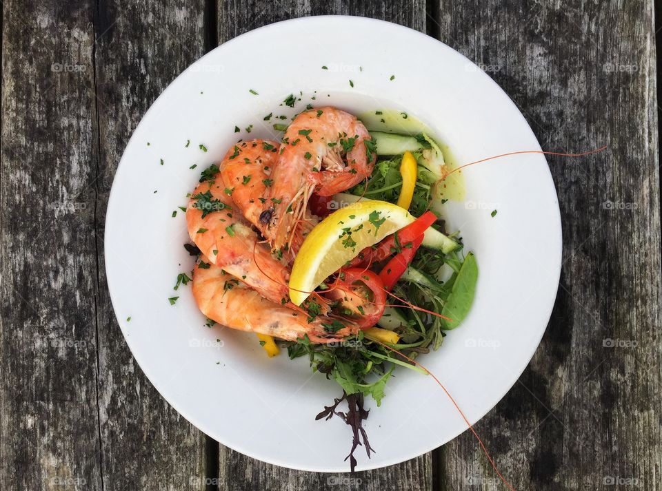 A Flatlea food image of a seafood platter with juicy prawns salad and lemon in a square Instagram style frame