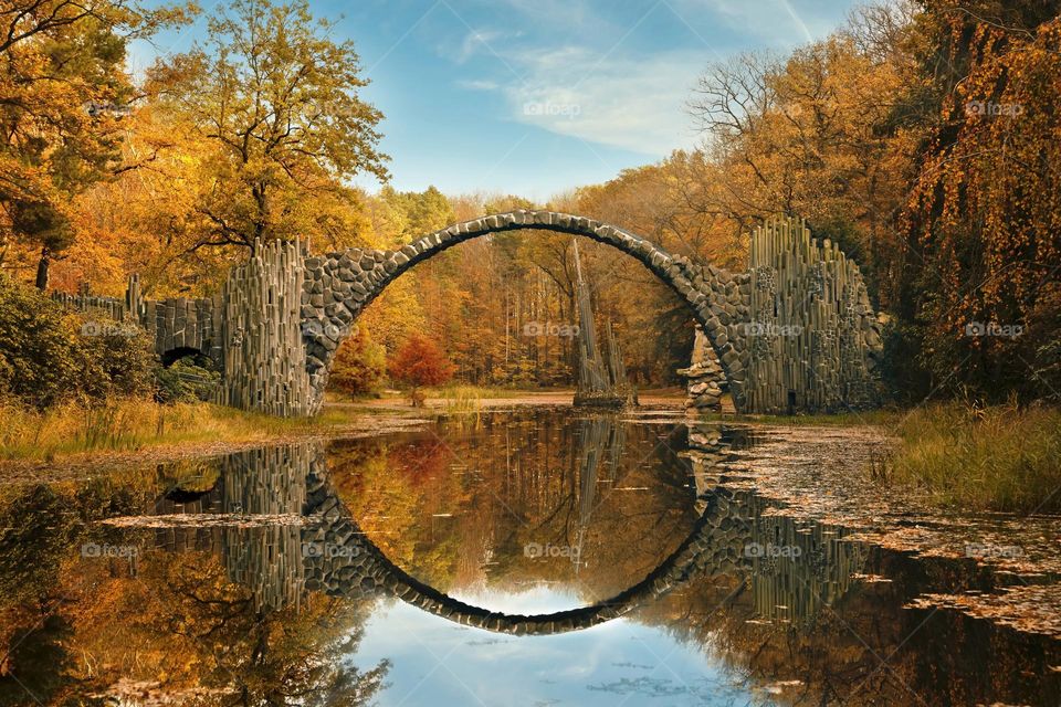 Round bridge with reflection in autumn park