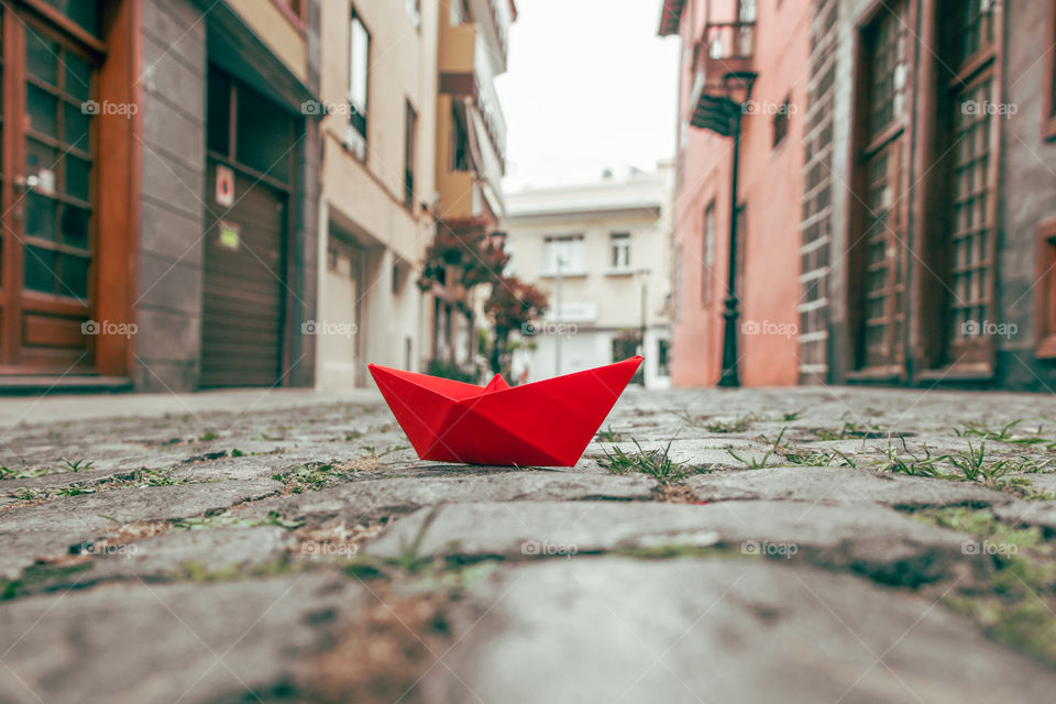 Red paper boat on the street