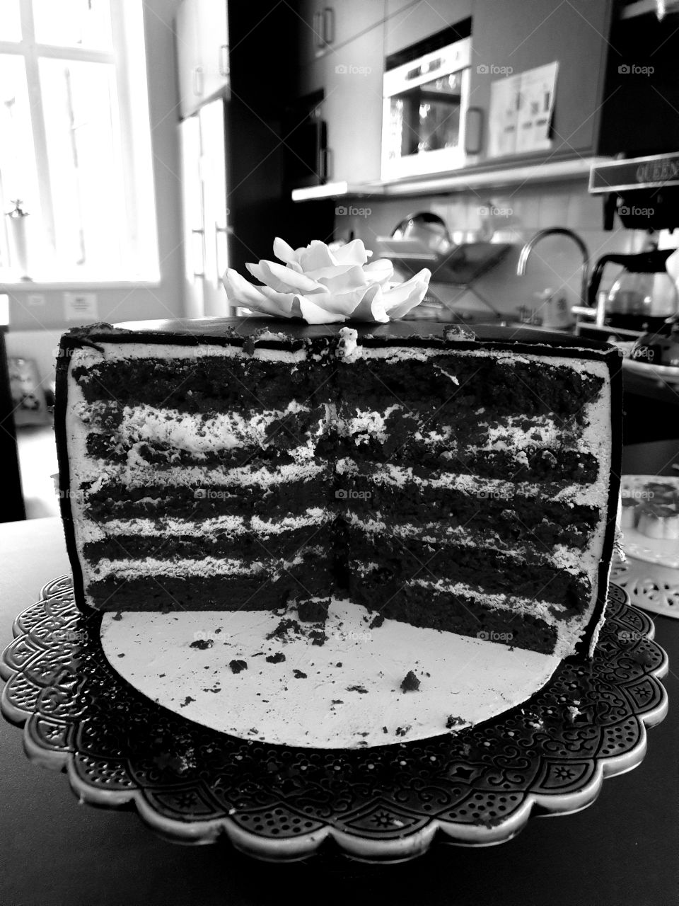 Half eaten cake in a kitchen. Black and white.