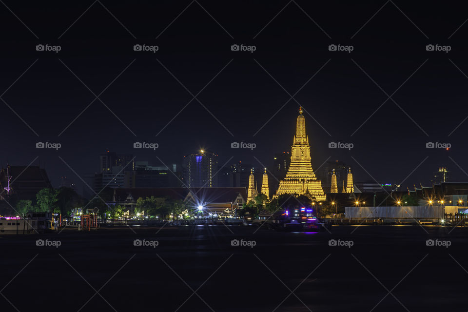 Wat Arun at night with gold and is the oldest temple of the Chao Phraya River. in Bangkok Thailand.