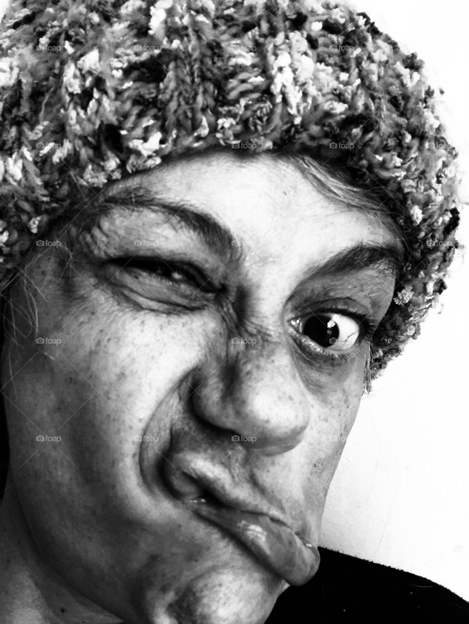 Woman in a wool hat shows her emotions for being stuck indoors during a particular cold winter weekend.