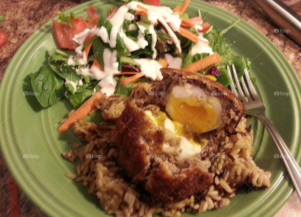 Scotch egg and salad. my first attempt. sausage wrapped soft boiled egg on a bed of rice to catch the creamy yolk.