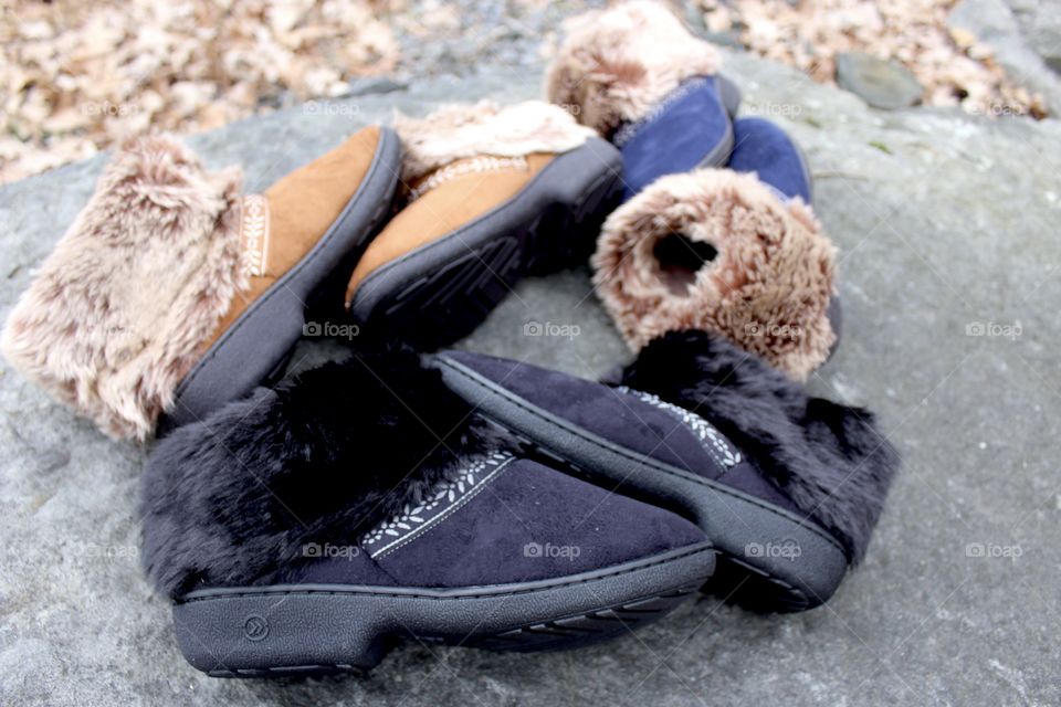 Three colorway slippers resting on rock