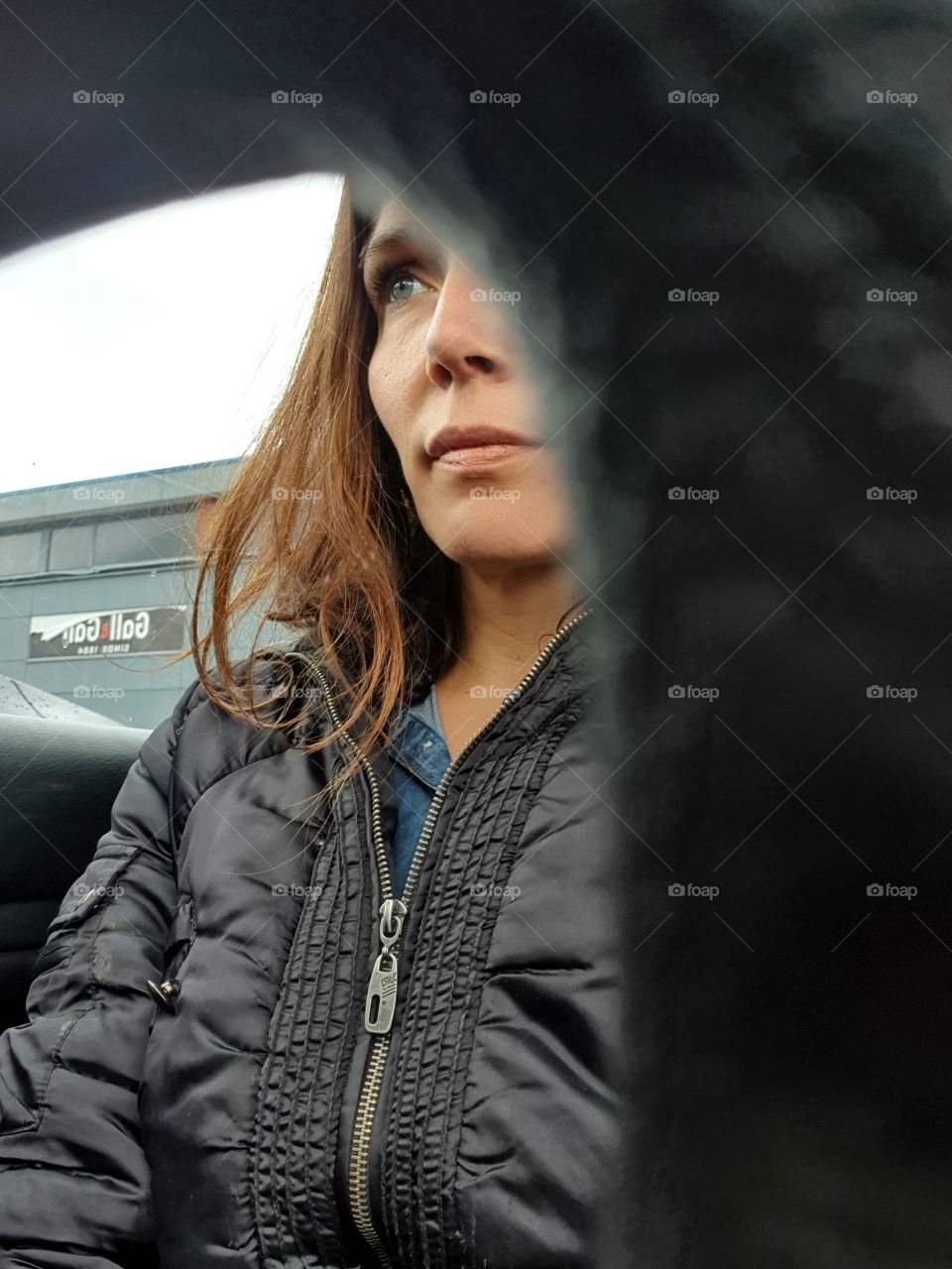 In the car behind the wheel