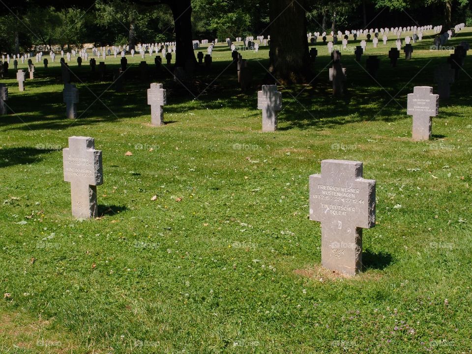 Beautiful finely carved tombstones of fallen German Soldiers in a beautifully landscaped cemetery outside of Luxembourg City on a nice summer day. 