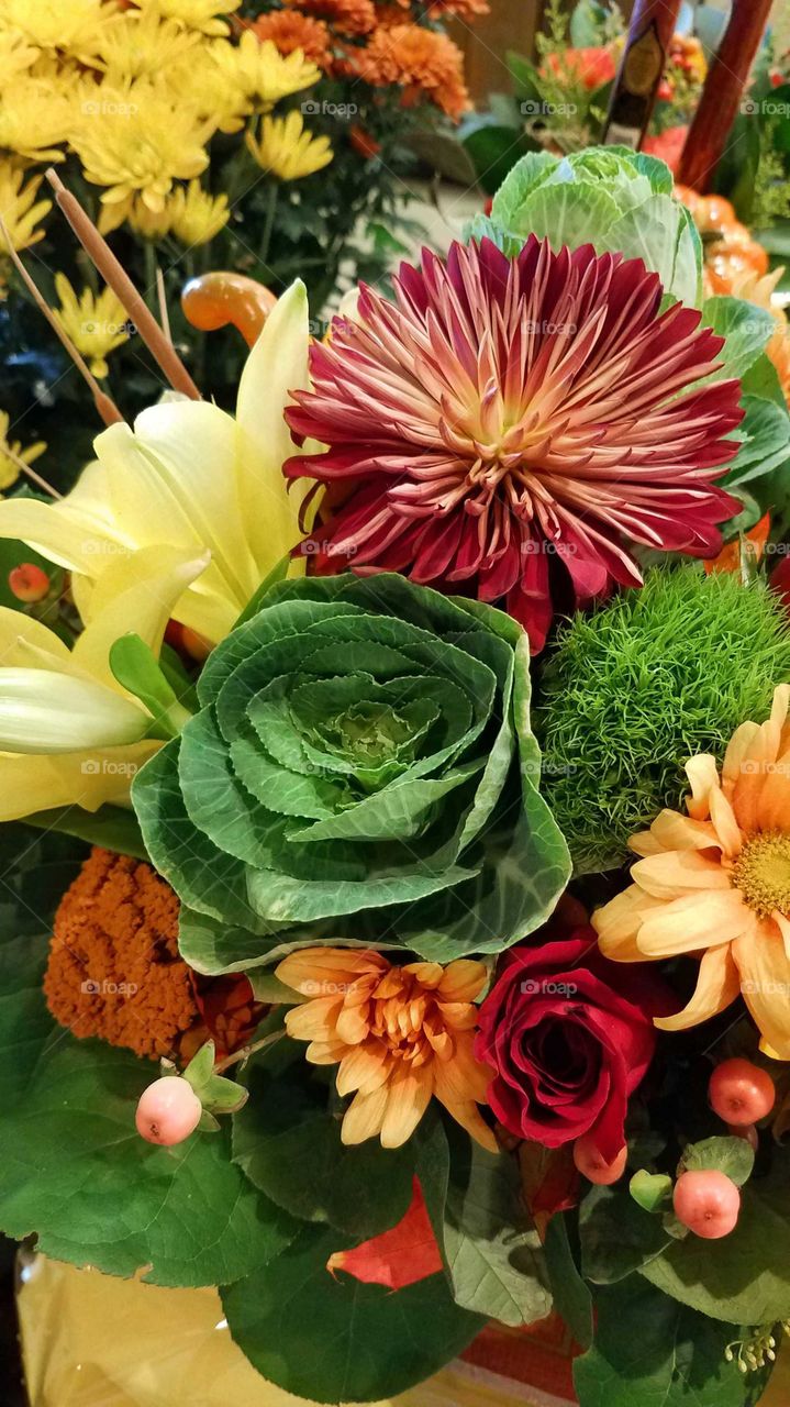A colorful autumn holiday bouquet with cattails, cabbages, lilies, mums, etc.