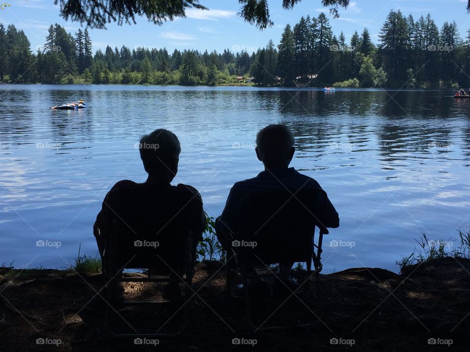 Sitting in the shade by a lake.