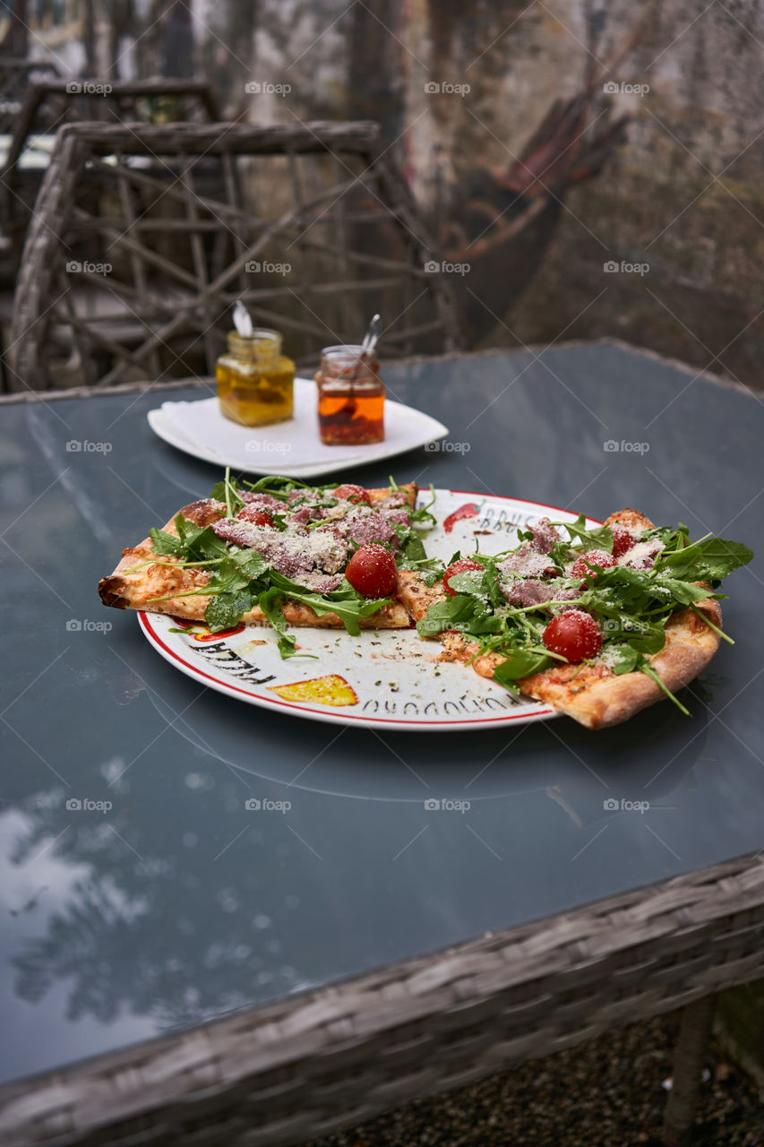 Pizza with rocket, ham and cherry tomatoes 