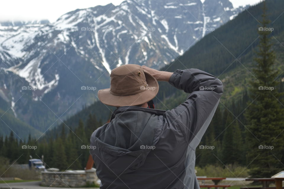 Male photographer shooting scenery with camera in the Canadian Rocky Mountains