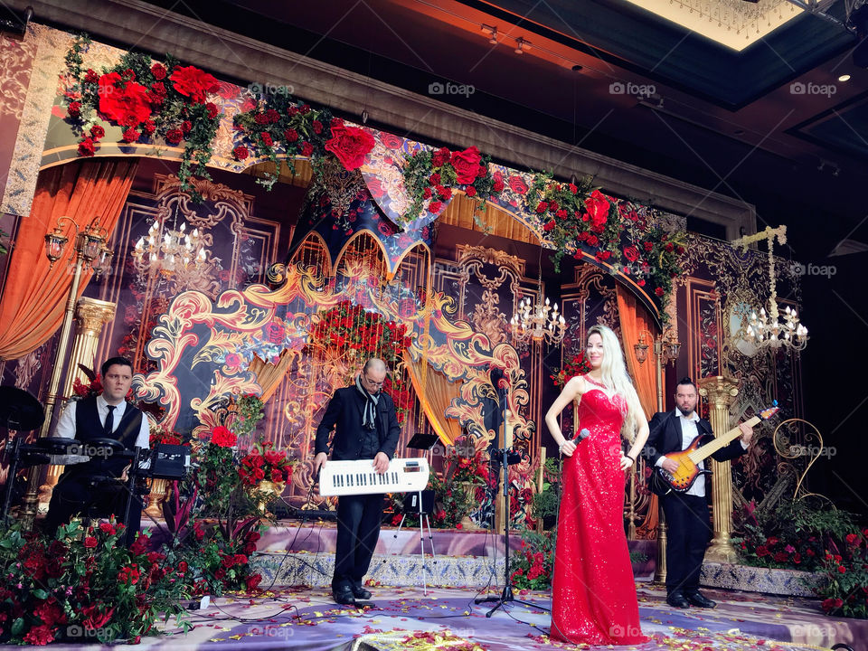 Beautiful wedding birthday event music live band, drums bass key, singer with red long dress and musicians wearing elegant suits 