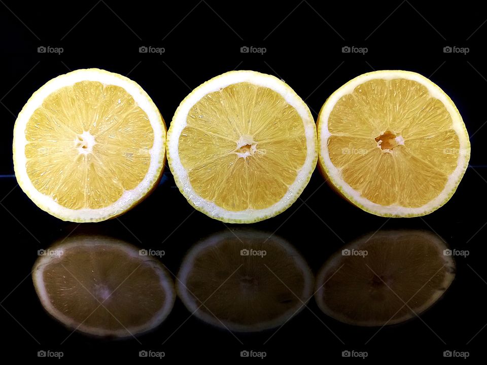 reflection on black glass of lemon slices