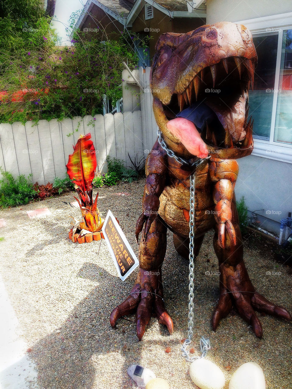 Rusty funky Tyrannosaurus rex statue in a California home garden