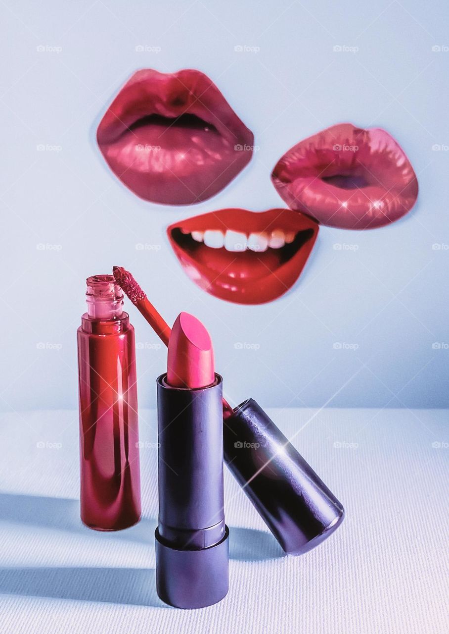 Lipstick & Lipgloss in front of cut out shapes of lips, with a touch of sparkle for added glamour