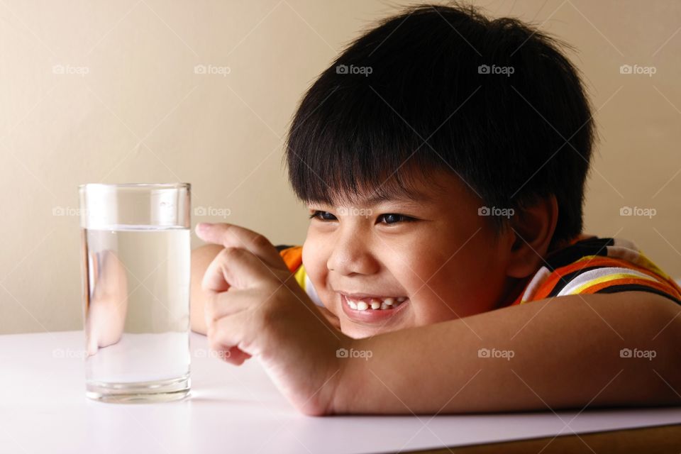 child touching a glass of water