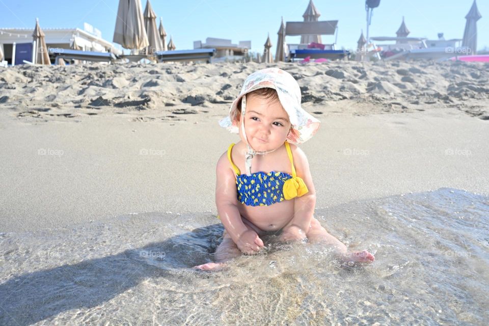 little girl playing and smiling by the sea