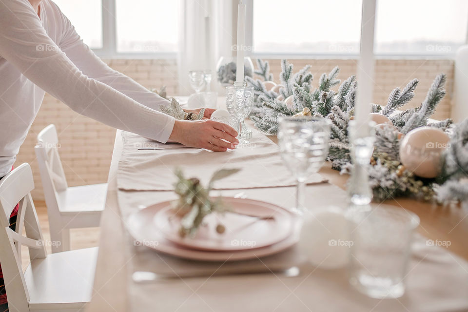 man sets a beautiful decorated winter table for a festive dinner.  Merry Christmas and Happy New Year.