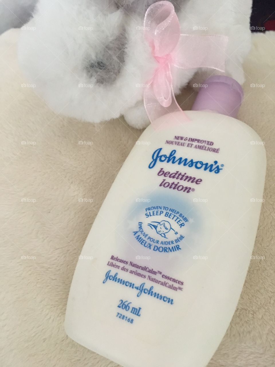 Johnson’s Bedtime Lotion on cream plush background with white bunny. 
