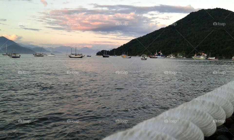 Belas águas, navios e lanchas em praia brasileira.