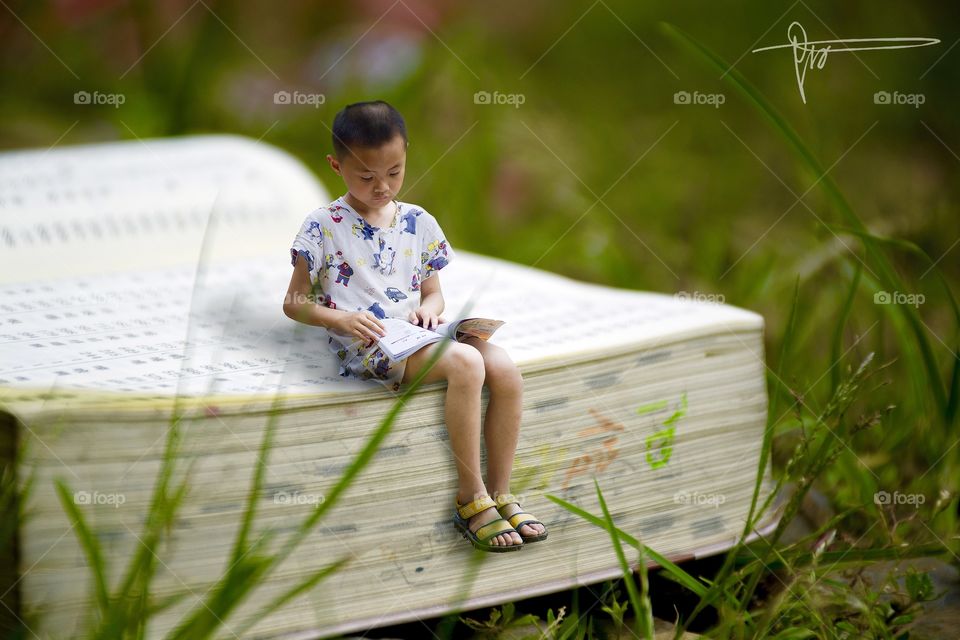 Little Boy Sitting on A Book
