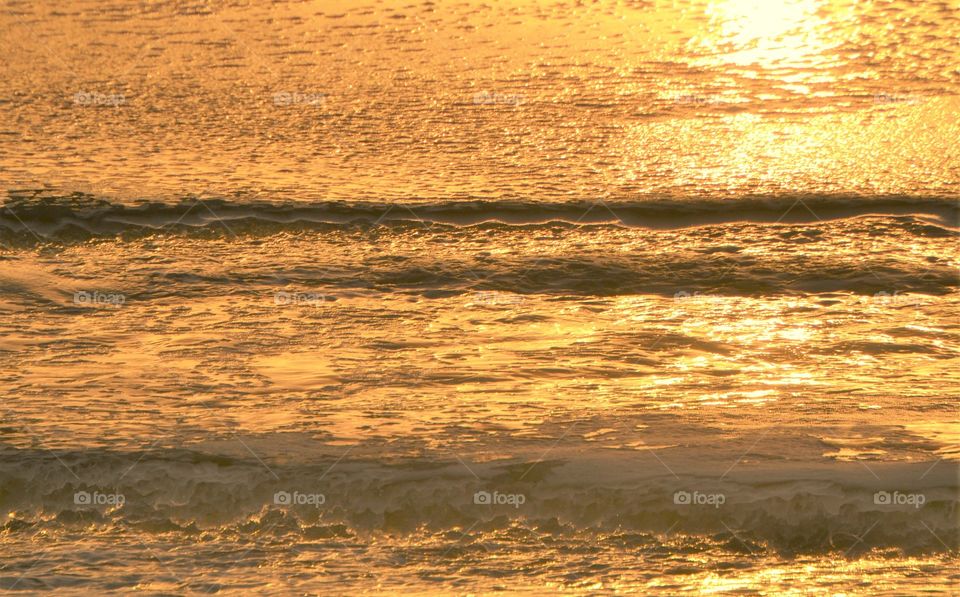 Ocean water at sunset , orange