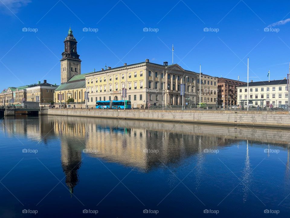 Reflection of house and blue bus in water