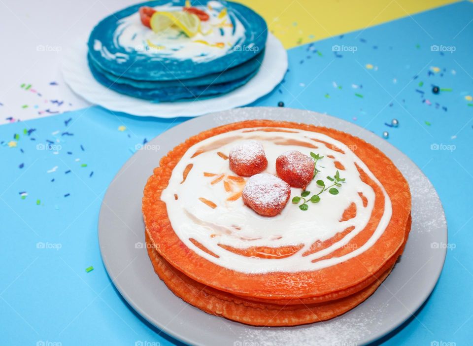 Orange and blue pancakes with sour cream with candied fruit.  Excellent breakfast