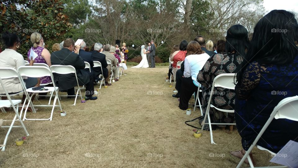 An outdoor wedding looking down the center aisle