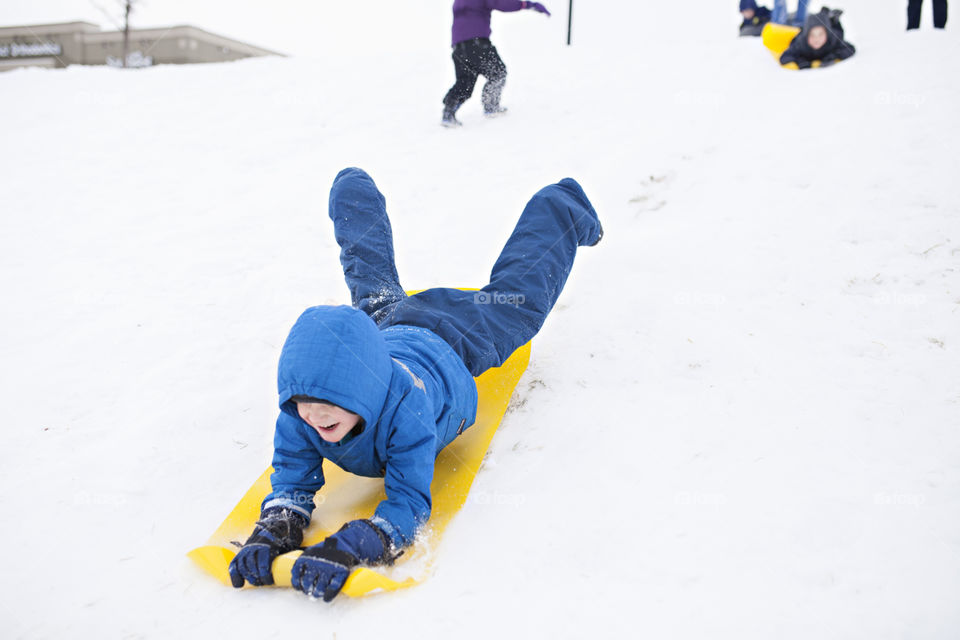 Boy sledding in the snow 