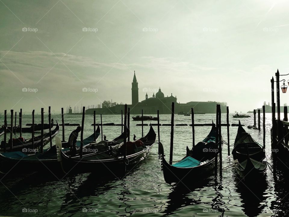Venice, Italy is an atmospheric city.  Gondolas sit in St. Mark's basin, looking toward the monastery of San Giorgio.