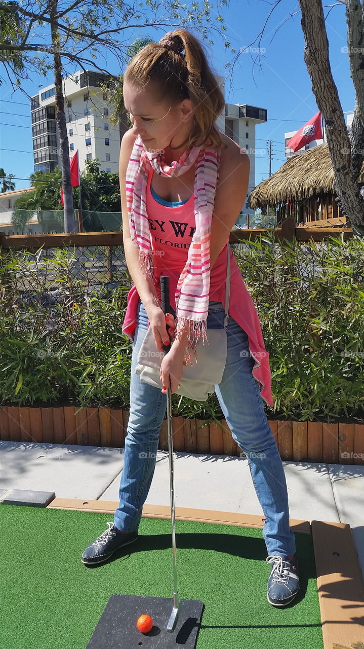 Girl playing mini golf