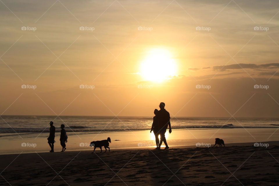 Panoramic coastline views and leisure walks during sunset hours in Seminyak area of Bali island. 