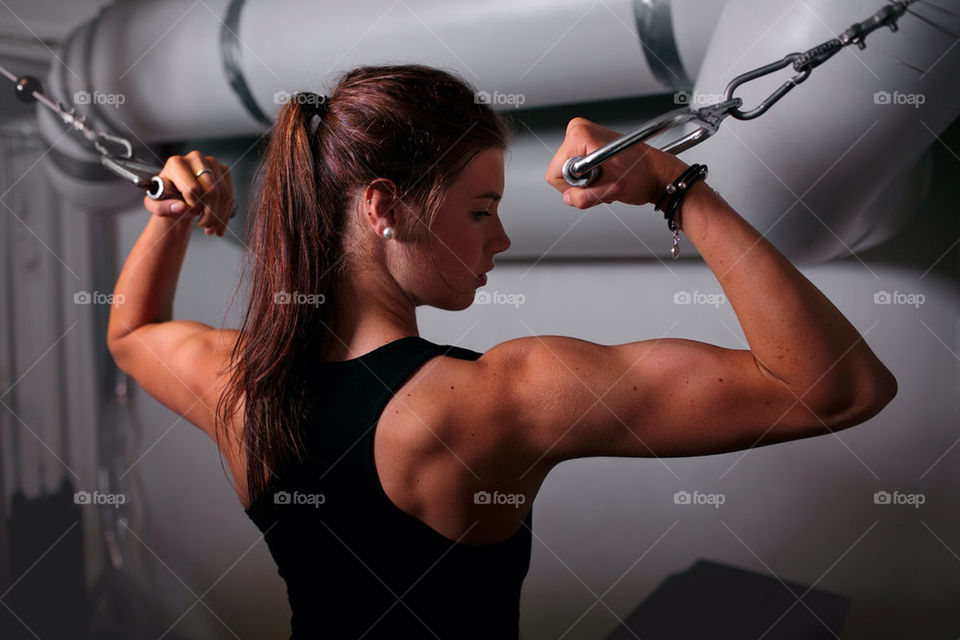 Fit girl doing bicep curls in cablecross