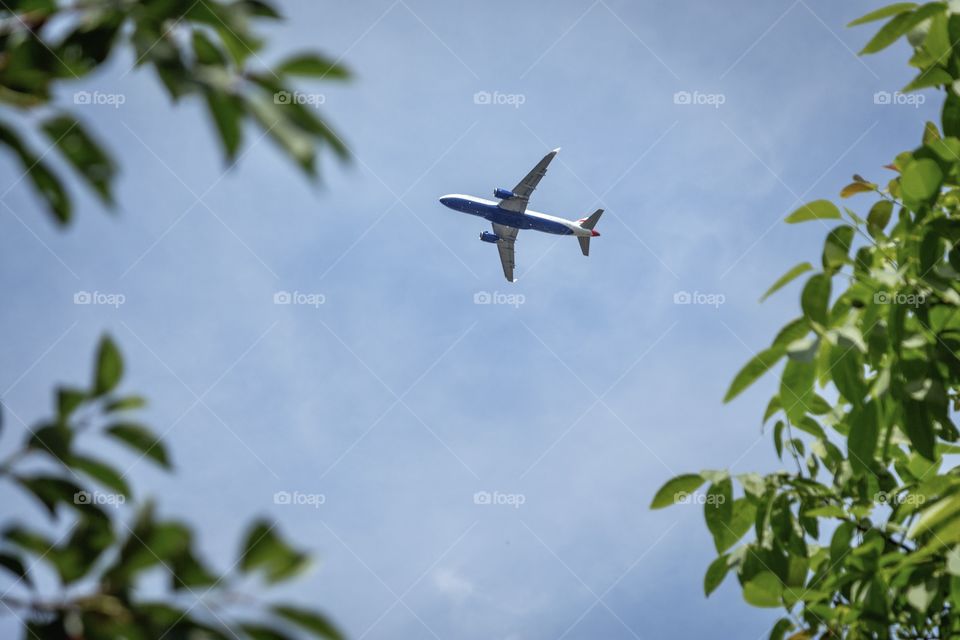 Flying white passenger plane high in the sky
