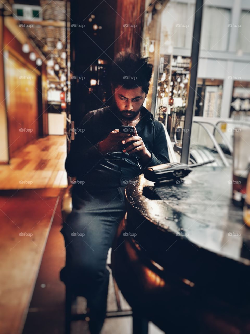 Young man using mobile phone in restaurant