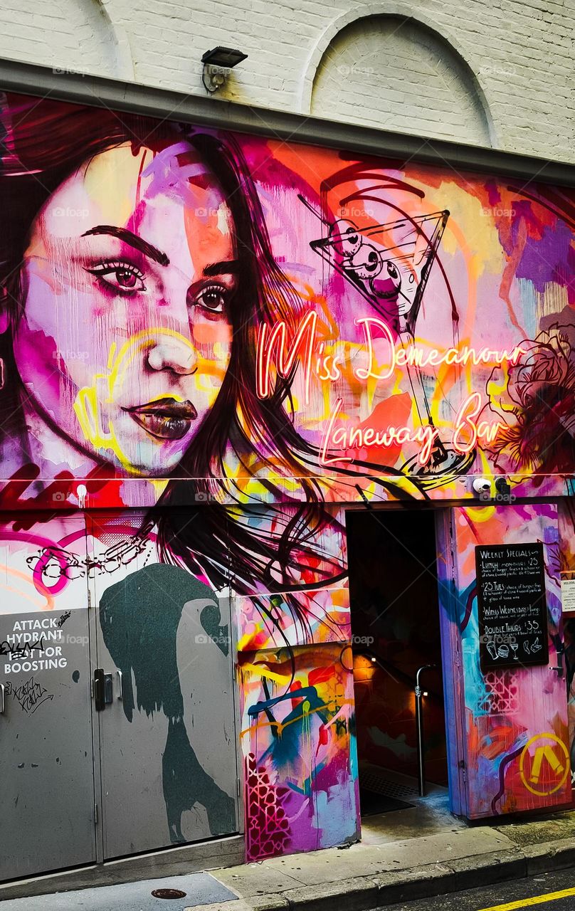Colourful woman head graffiti at the entrace of Miss Demeanour bar on Rowes Lane in Brisbane