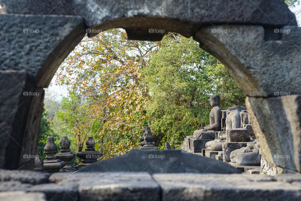 buddha statue framed with stone in borobudur temple