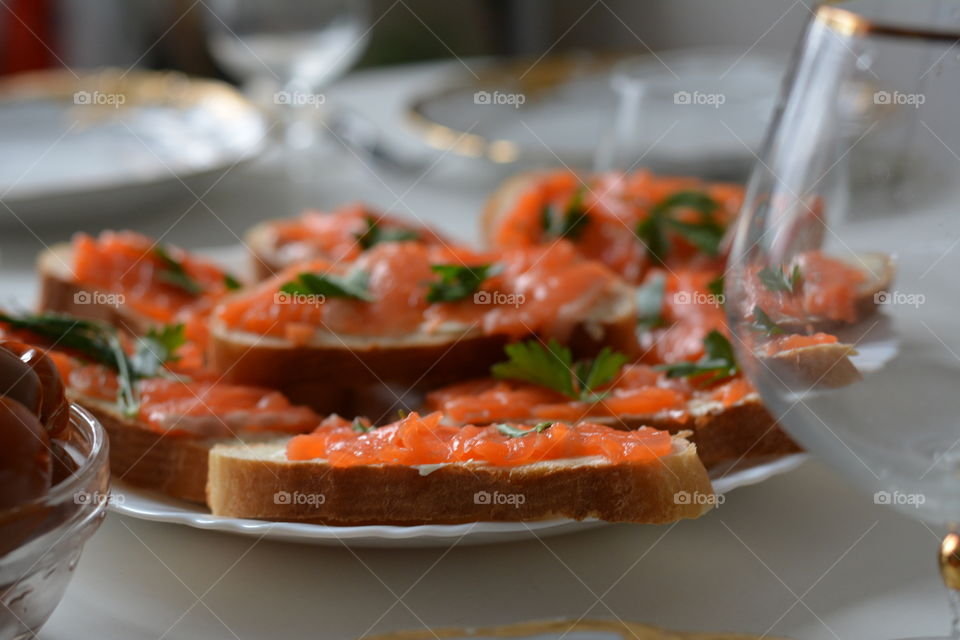 family eating home sandwiches with red fish on a table and dishes