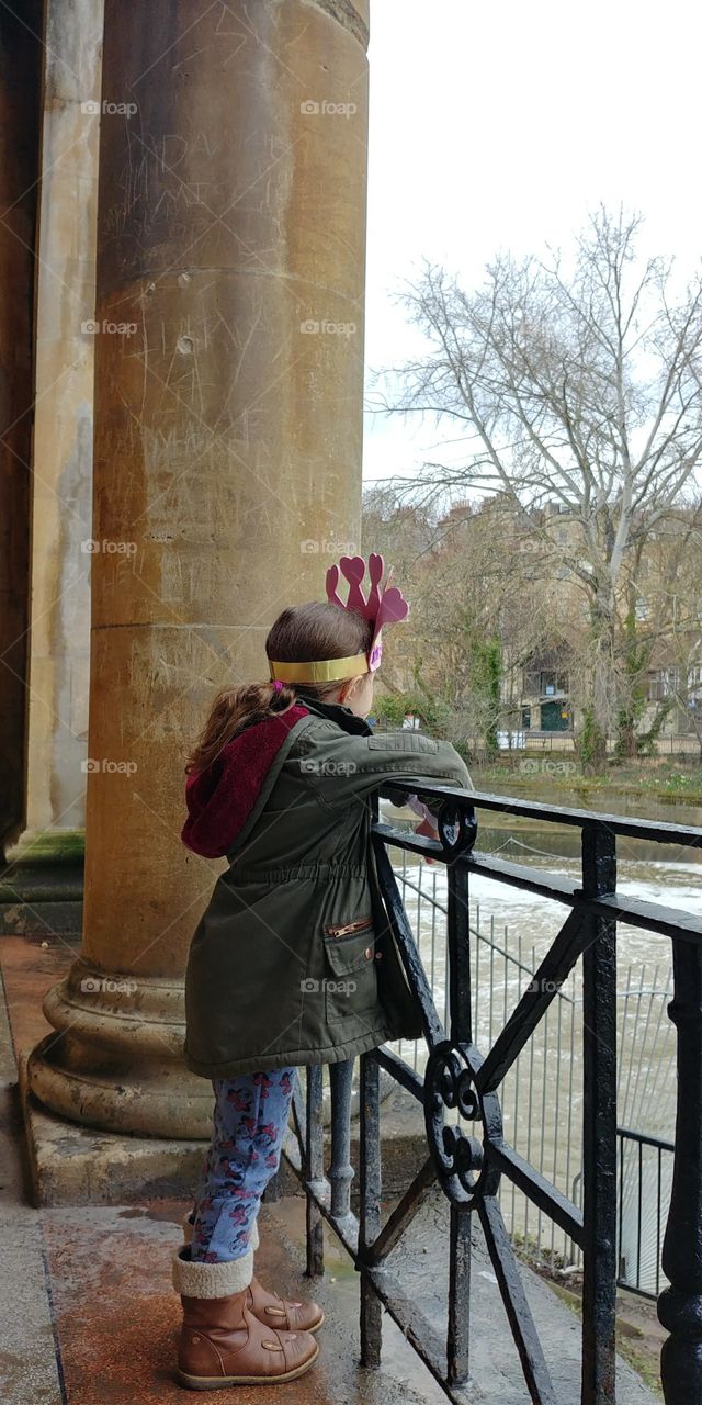 little girl looking out over railing at River