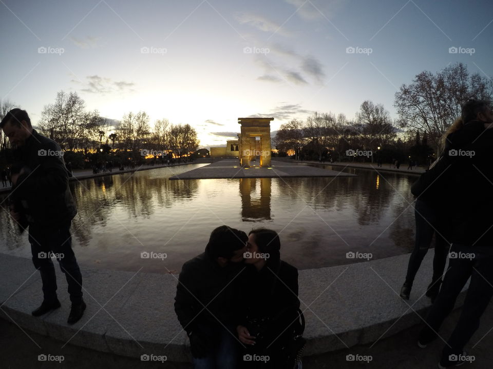 A couple kissing in-front of the Egyptian temple of depot, Madrid, Spain by the sunset.