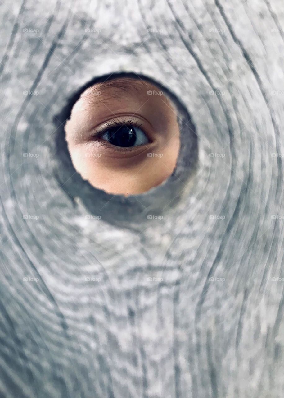 Child looking through a hole