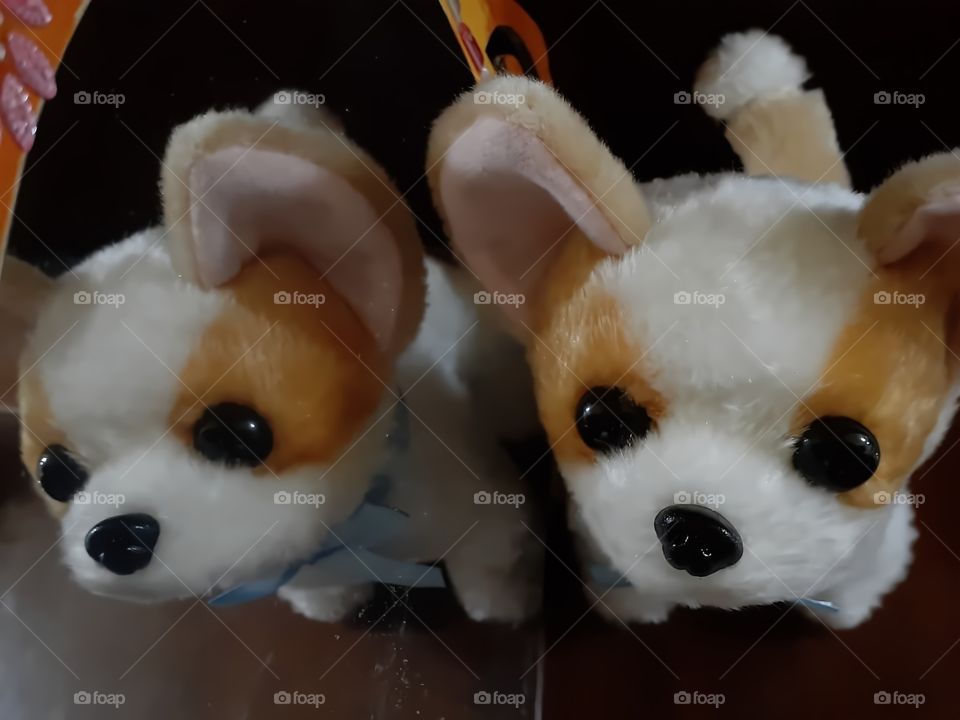 little dog (toys) sitting above the table while in its right side , the plastic mirror is located.