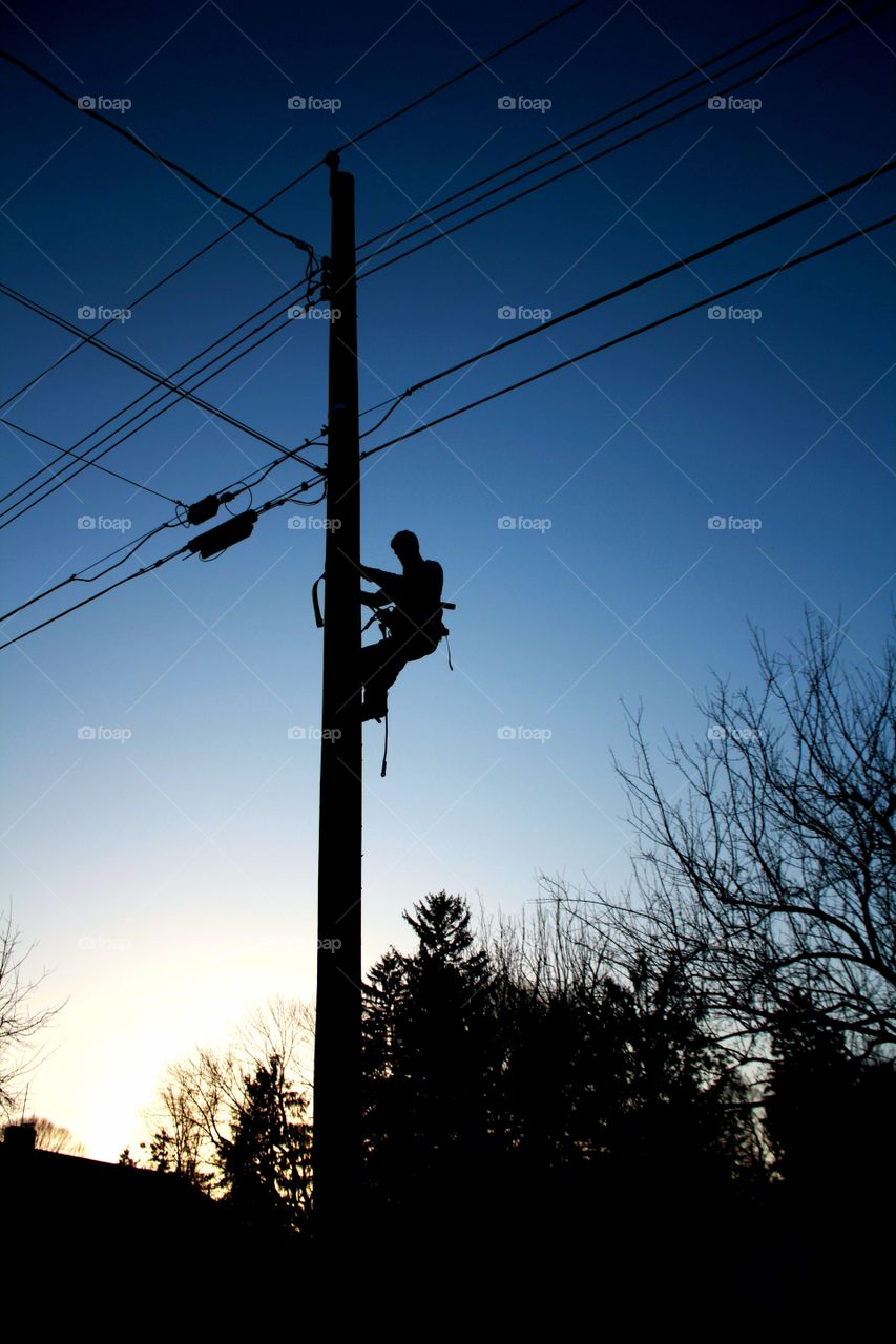 Lineman. Sillouhette of a lineman doing his job