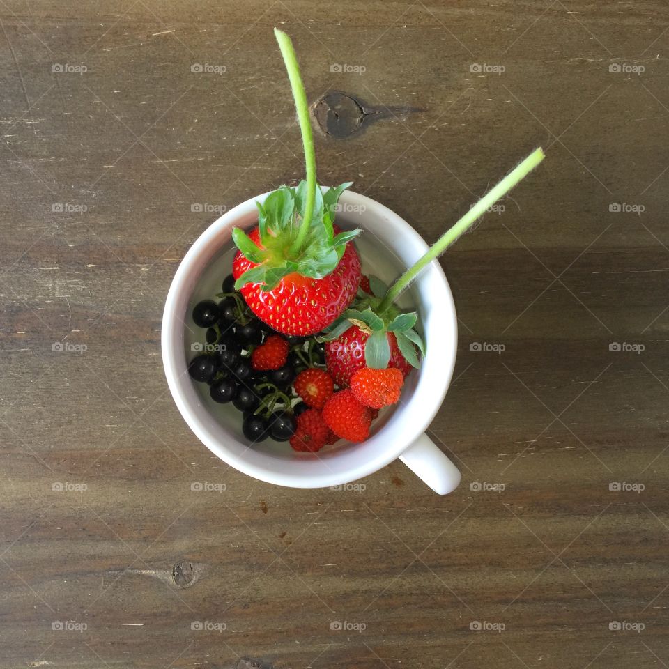 Berries in cup on table